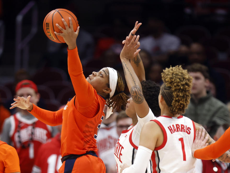 Illinois guard Makira Cook, left, shoots in front of Ohio State guards Hevynne Bristow, center, and Rikki Harris (1) during the second half of an NCAA college basketball game in Columbus, Ohio, Sunday, Jan. 8, 2023. (AP Photo/Paul Vernon)