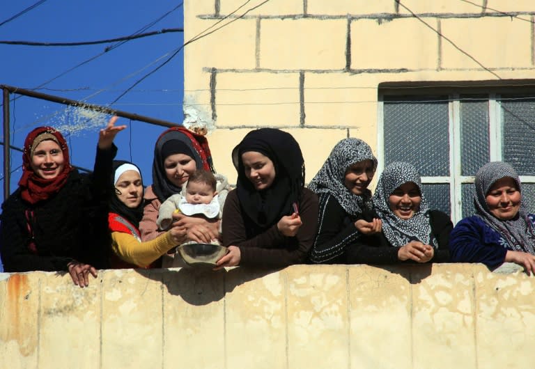 Syrians celebrate after pro-government forces broke an opposition siege in the northern Shiite town of Nubol