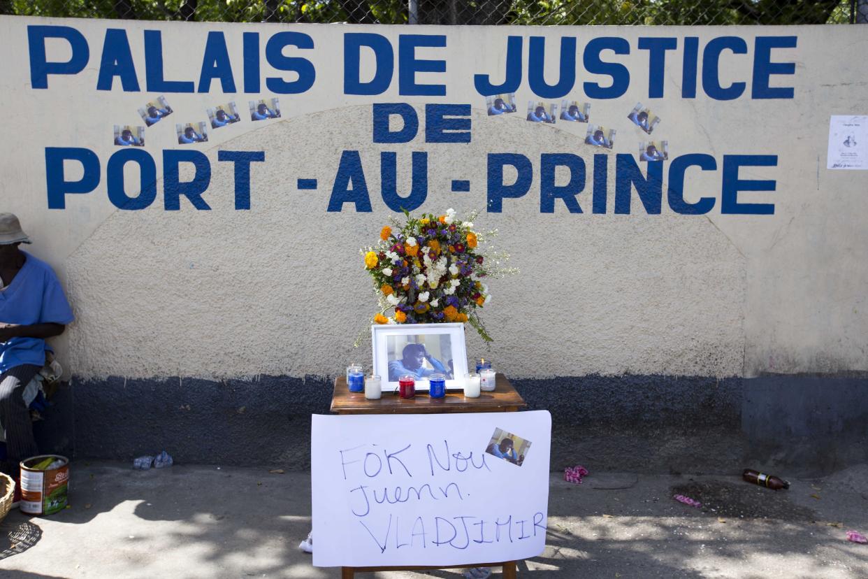 Flowers, candles and a sign with a message that reads in Creole: "We must find Vladjimir," adorn a makeshift memorial dedicated to missing photojournalist Vladjimir Legagneur, during a sit-in outside a courthouse organized by the Association of Journalists, in Port-au-Prince, Haiti, Monday, June 4, 2018. Legagneur disappeared on March 14 after entering the community of Grand Ravine, considered one of the poorest and most dangerous in Port-au-Prince. He has not been heard of since, and none of his belongings have been found as anger and frustration grows over a lack of answers from police and justice officials. (AP Photo/Dieu Nalio Chery)