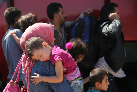 A woman holds her child outside the Kokkinotrimithia refugee camp outside Nicosia, Cyprus September 10, 2017. REUTERS/Yiannis Kourtoglou