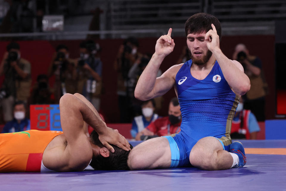 Russia's Zavur Uguev (blue) reacts after defeating India's Kumar Ravi in their men's freestyle 57kg wrestling final match during the Tokyo 2020 Olympic Games at the Makuhari Messe in Tokyo on August 5, 2021. (Photo by Jack GUEZ / AFP) (Photo by JACK GUEZ/AFP via Getty Images)