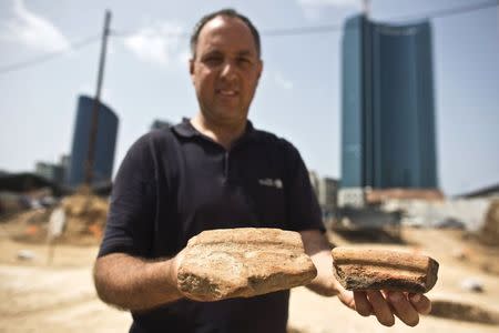 Diego Barkan, director of the excavation for the Israel Antiquities Authority (IAA), shows fragments of ancient basins unearthed at an archaeological dig in a future construction site in Tel Aviv March 29, 2015. REUTERS/Nir Elias