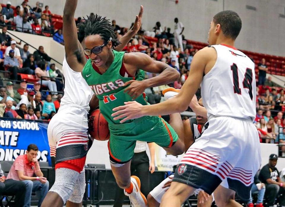 Blanche Ely HS Michael Forrest flies between Jacksonville Creekside HS defenders in the 8A Finals 2018 Basketball State Championships in Lakeland, Florida, March 10, 2018.