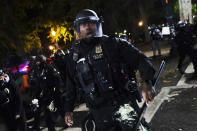 A Portland police officer pushes back protesters, Saturday, Sept. 26, 2020, in Portland. The protests, which began over the killing of George Floyd, often result frequent clashes between protesters and law enforcement. (AP Photo/John Locher)