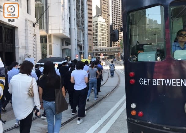 人群佔用一條行車線，阻礙電車行駛。