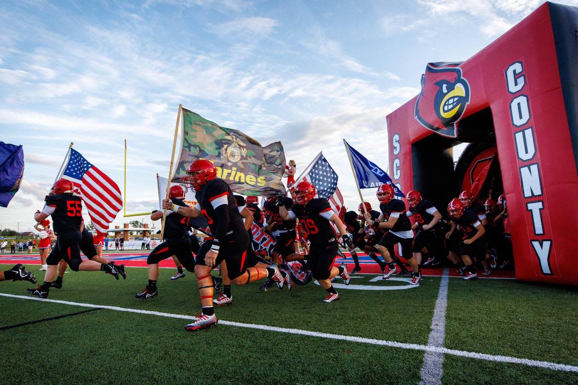 Scott County Cardinals players run onto the field before their game against the Bryan Station Defenders on Friday, Sept. 9, 2022, at Great Crossing High School in Georgetown, Kentucky.