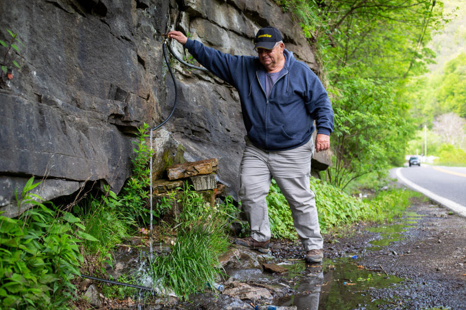 McDowell County Commissioner Cody Estep draws water from a mountain spring, the only source of drinking water for many residents. (Hannah Rappleye / NBC News)