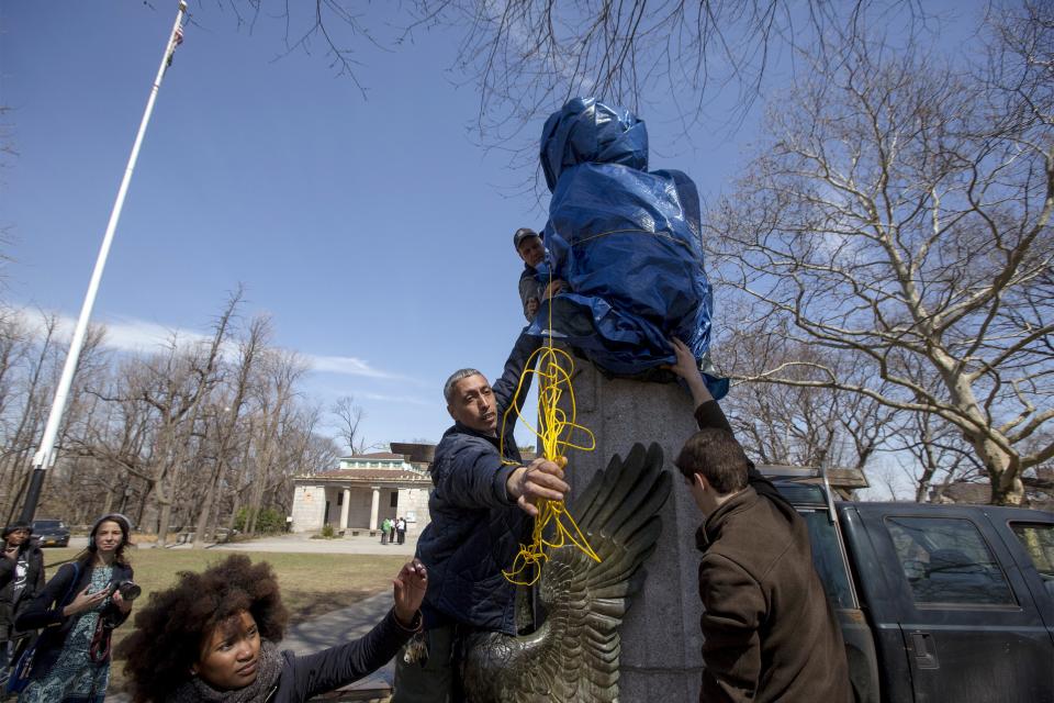 New York City Parks workers work to remove a covered large molded bust of Edward Snowden at Fort Greene Park in the Brooklyn borough of New York