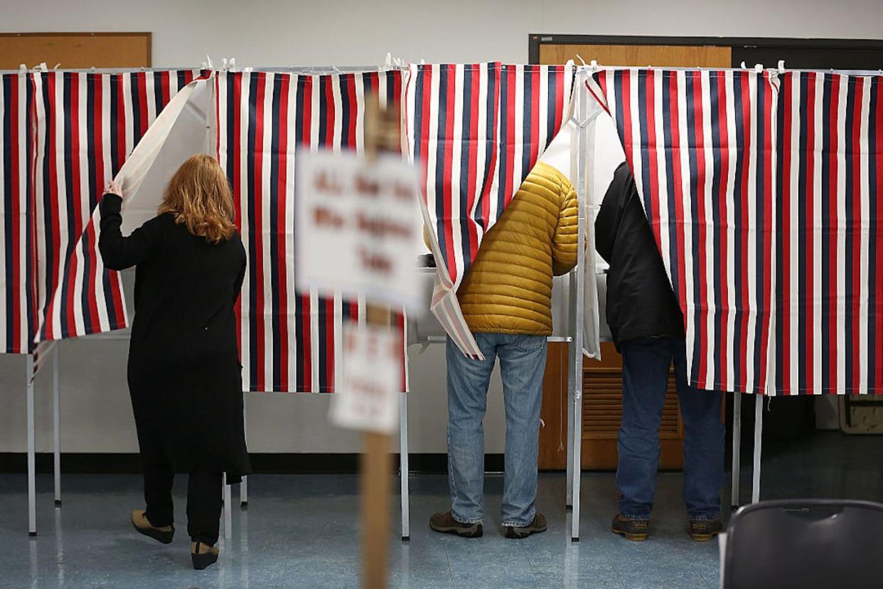 Religion shapes how many people vote – and lack of religion does, too. <a href="https://www.gettyimages.com/detail/news-photo/primary-day-voters-use-voting-booths-as-they-cast-their-news-photo/509150980" rel="nofollow noopener" target="_blank" data-ylk="slk:Joe Raedle/Getty Images News via Getty Images;elm:context_link;itc:0;sec:content-canvas" class="link ">Joe Raedle/Getty Images News via Getty Images</a>