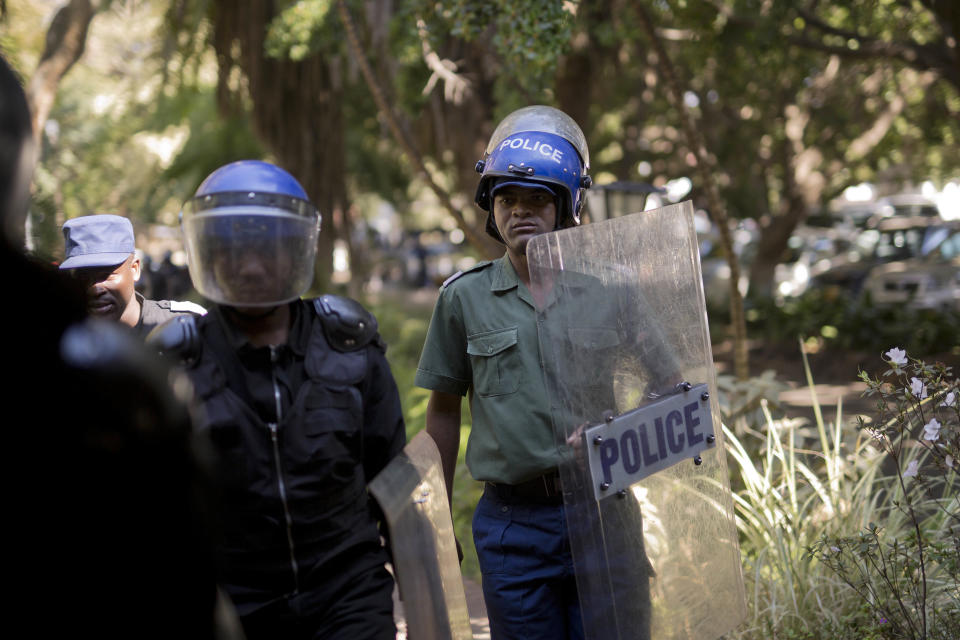 Riot police enters the Bronte hotel where a press conference by opposition leader Nelson Chamisa was scheduled to take place, in Harare, Zimbabwe, Friday Aug. 3, 2018. Hours after President Emmerson Mnangagwa was declared the winner of a tight election, riot police disrupted a press conference where opposition leader Nelson Chamisa was about to respond to the election results. (AP Photo/Jerome Delay)