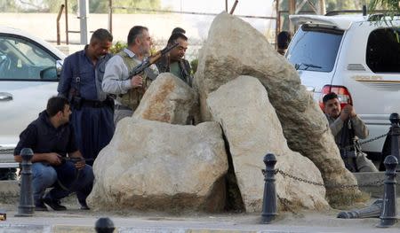 Peshmerga forces stand behind rocks at a site of an attack by Islamic State militants in Kirkuk, Iraq, October 21, 2016. REUTERS/Ako Rasheed