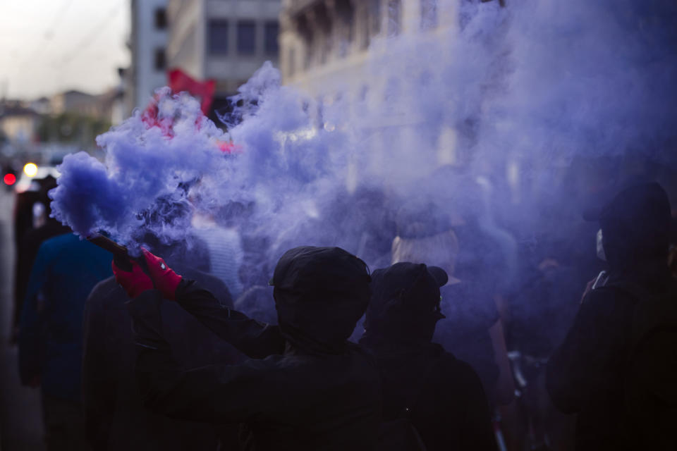 Protesters burn smoke petards during a demonstration against the World Economic Forum (WEF) in Zurich, Switzerland, Friday, May 20, 2022. The World Economic Forum Annual Meeting will take place from May 22 to 26, in Davos. (Michael Buholzer/Keystone via AP)