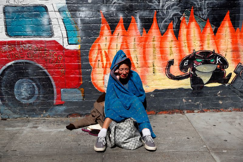 FILE PHOTO: A woman sits with her belongings on the sidewalk n the Tenderloin area of San Francisco, California