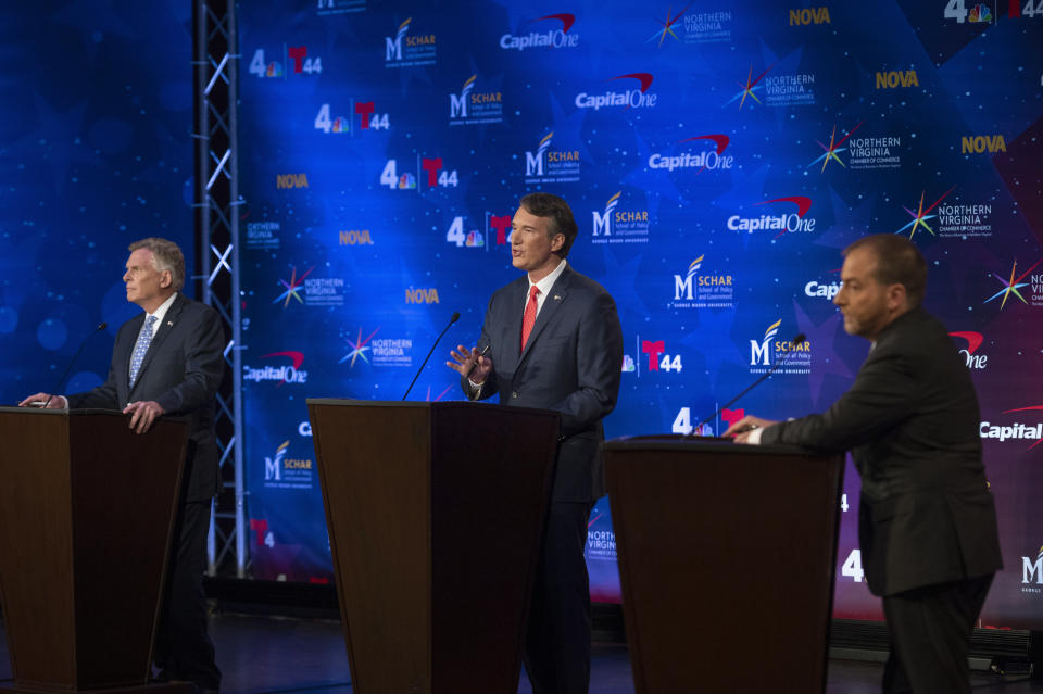 Virginia Democratic gubernatorial candidate and former Gov. Terry McAuliffe, left, debates Republican challenger, Glenn Youngkin, while moderator Chuck Todd, right, looks on, at Northern Virginia Community College, in Alexandria, Va., Tuesday, Sept. 28, 2021. (AP Photo/Cliff Owen)