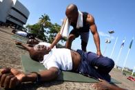 El sargento Felixon Musa, profesor de yoga para las fuerzas armadas de Sierra Leona ayuda a un soldado a elongar durante una clase en una base militar de Freetown.