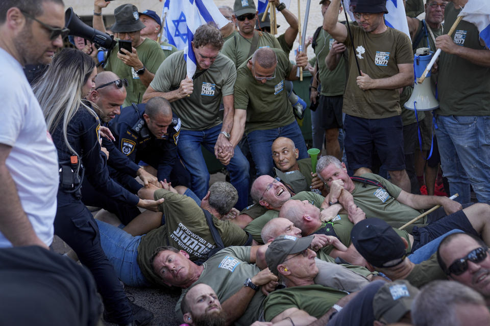 FILE - Israeli police disperse demonstrators, mostly military reservists, who block a road outside the house of Israeli Justice Minister Yariv Levin during a protest against plans by Prime Minister Benjamin Netanyahu's government to overhaul the judicial system, in Modiin, Israel, Monday, Sept. 11, 2023. Netanyahu's government, made up of ultranationalist and ultra-religious parties, was formed last year and immediately pressed ahead with a contentious plan to reshape the country's judiciary. (AP Photo/Ohad Zwigenberg, File)