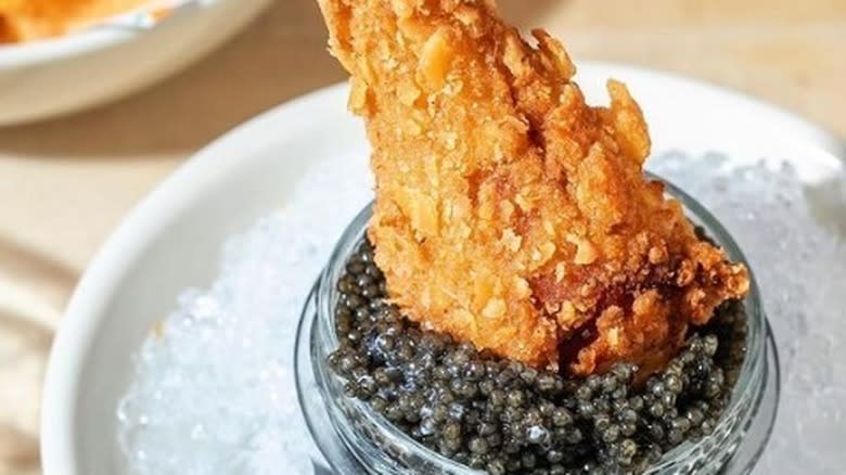 Fried chicken dipping in caviar