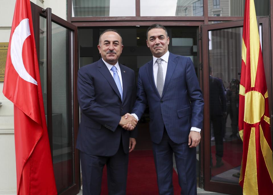 Turkey's Foreign Minister Mevlut Cavusoglu, left, shakes hands with North Macedonia's Foreign Minister Nikola Dimitrov, right, prior to their meeting, in Skopje, North Macedonia, Tuesday, July 16, 2019. Cavusoglu on Tuesday downplayed as "worthless" an initial set of sanctions approved by the European Union against Ankara and vowed to send a new vessel to the eastern Mediterranean to reinforce its efforts to drill for hydrocarbons off the island of Cyprus. EU foreign ministers on Monday approved sanctions against Turkey over its drilling for gas in waters where EU member Cyprus has exclusive economic rights. (Cem Ozdel/Turkish Foreign Ministry via AP, Pool)