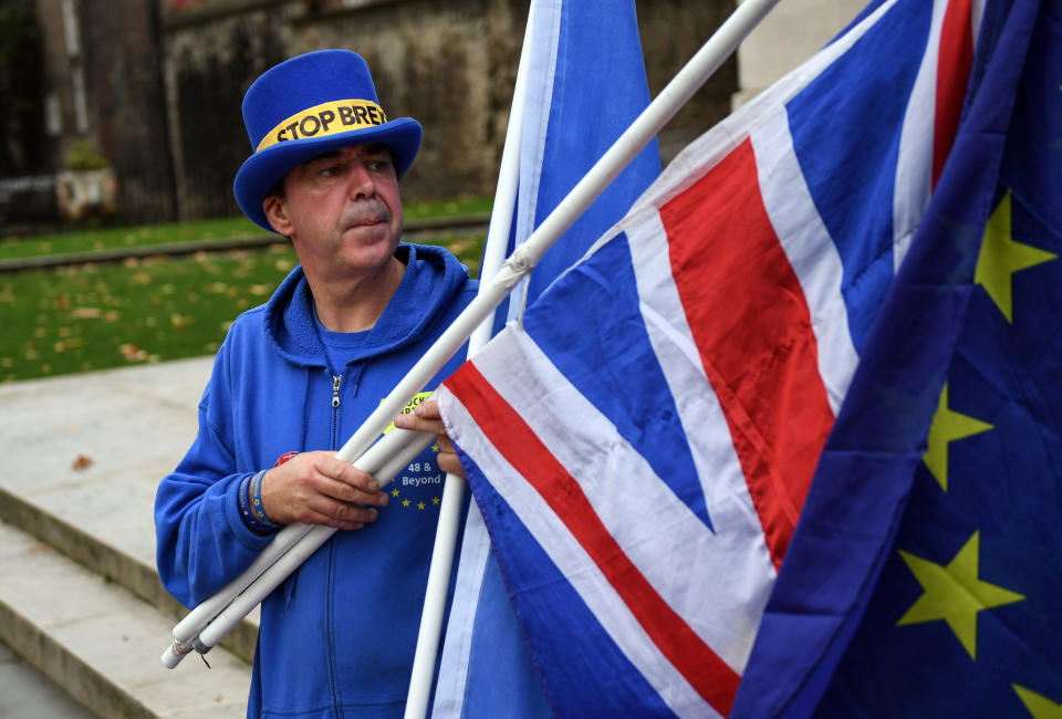 An anti-Brexit demonstrator holds a European Union flag and a British Union flag, also known as a Union Jack, in London Thursday. (Photo: Bloomberg via Getty Images)
