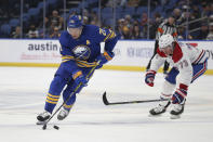 Buffalo Sabres right wing Kyle Okposo (21) skates with the puck by Montreal Canadiens right wing Tyler Toffoli (73) during the second period of an NHL hockey game on Friday, Nov. 26, 2021, in Buffalo, N.Y. (AP Photo/Joshua Bessex)