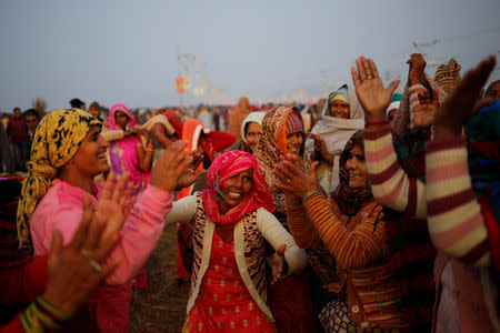 Devotees sing and dance after taking a holy dip at Sangam, the confluence of the Ganges, Yamuna and Saraswati rivers, during "Kumbh Mela", or the Pitcher Festival, in Prayagraj, previously known as Allahabad, India, January 14, 2019. REUTERS/Danish Siddiqui