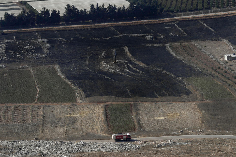 A Lebanese firefighters truck passes along the border with Israel next of fields that burned on Sunday by the Israeli army shells, in the southern Lebanese border village of Maroun el-Ras, Lebanon, Monday, Sept. 2, 2019. Hezbollah militants on Sunday fired a barrage of anti-tank missiles into Israel, prompting a reprisal of heavy Israeli artillery fire in a rare burst of fighting between the bitter enemies.(AP Photo/Hussein Malla)