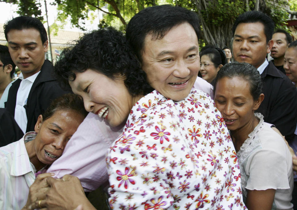 FILE - Thai supporters embrace Thailand's deposed Prime Minister Thaksin Shinawatra at Bovorn Rachanivej Temple in Bangkok in this March 18, 2006. Thaksin Shinawatra, a controversial former Prime Minister of Thailand, made his dramatic return to Thailand last year after nearly a decade of self-imposed exile. Although he was detained in a hospital and never appeared in the public eye for six months after his arrival, his presence in the country alone brings a turmoil into Thai politics like no other politician could ever achieve. (AP Photo/Sakchai Lalit,File)