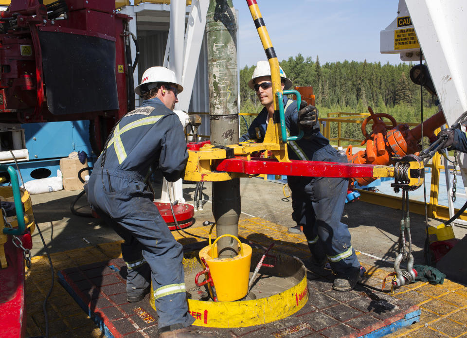 Oil rig floorhands from Akita Drilling work on an oil rig at the Cenovus Energy Christina Lake Steam-Assisted Gravity Drainage (SAGD) project 120 km (74 miles) south of Fort McMurray, Alberta, August 15, 2013. Cenovus currently produces 100,000 barrels of heavy oil per day at their Christina Lake tar sands project. REUTERS/Todd Korol  (CANADA - Tags: ENERGY BUSINESS)