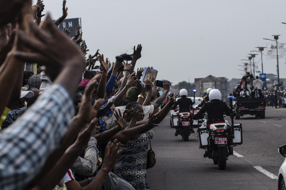 Well-wishers wave at Pope Francis in Kinshasa, Congo, Tuesday Jan. 31, 2023. Francis is in Congo and South Sudan for a six-day trip, hoping to bring comfort and encouragement to two countries that have been riven by poverty, conflicts and what he calls a "colonialist mentality" that has exploited Africa for centuries. (AP Photo/Samy Ntumba Shambuyi)