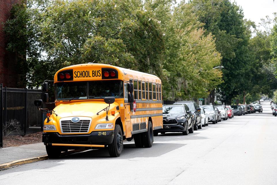 Cars line up along East 48th Street behind a single school bus as they wait for dismissal at Charles Ellis Montessori Academy.