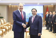 Russian Foreign Minister Sergey Lavrov and Vietnamese Prime Minister Pham Minh Chinh shake hands in Hanoi, Vietnam on Wednesday, July 6, 2022. (Duong Van Giang/VNA via AP)