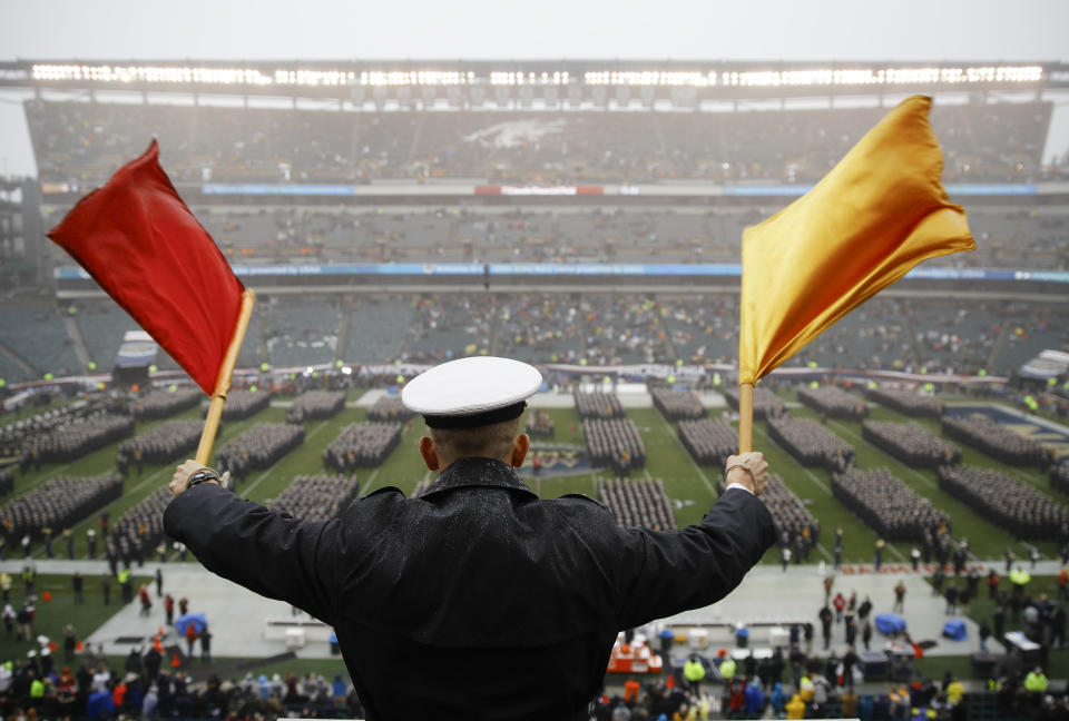 FILE - A Navy Midshipman signals his classmate on the field ahead of an NCAA college football game against Army in Philadelphia, in this Saturday, Dec. 14, 2019, file photo. Bump Army-Navy or go head-to-head with NFL? That's the choice facing those in charge with expanding the College Football Playoff if they want to take the format from four to 12 teams (AP Photo/Matt Rourke, File)