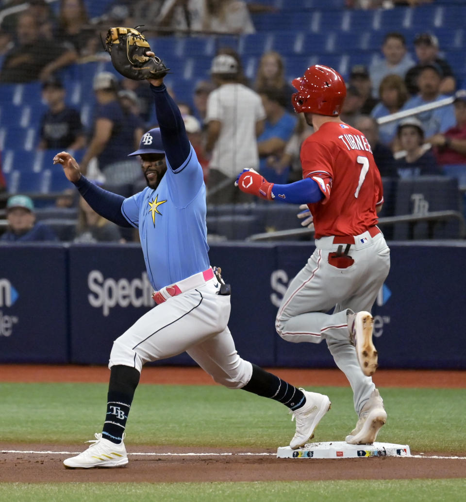 Philadelphia Phillies' Trea Turner (7) reaches first base on an infield single to beat the throw to Tampa Bay Rays' Yandy Diaz, left, during the first inning of a baseball game Thursday, July 6, 2023, in St. Petersburg, Fla. (AP Photo/Steve Nesius)