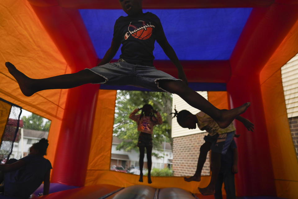 Kids jump around inside a bouncy castle during a Back To School Block Party in the Robinwood Community of Annapolis, Md., Sunday, Aug. 21, 2022. Community children were given donated school supplies and had fun. The block party was sponsored by the Nikiesha Thomas Memorial and Allstate Insurance and was hosted by Beacon Light Seventh-day Adventist Church. Nikiesha Thomas was shot and killed by her ex-boyfriend just days after filing for a protective order. Victims of abuse and their families saw a quiet breakthrough this summer when the passage of a bipartisan gun safety bill in Congress included a proposal that would make it more difficult for intimate partners of convicted domestic abusers to obtain firearms. (AP Photo/Carolyn Kaster)