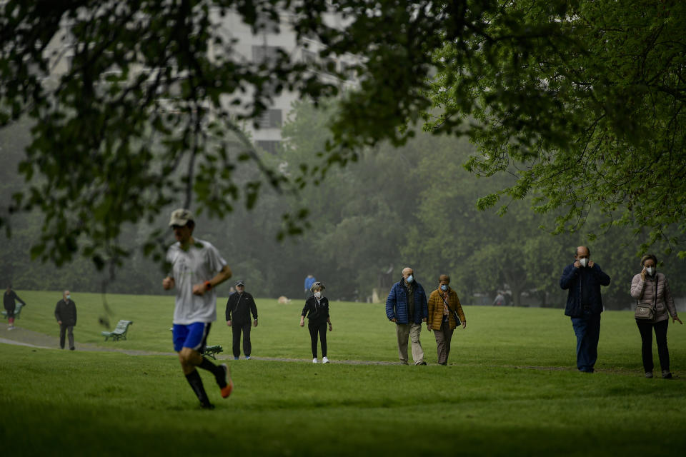 People wearing face masks to protect against coronavirus walk and exercise in Vuelta del Castillo park, in Pamplona, northern Spain, Saturday, May 2, 2020. Spain relaxed its lockdown measures Saturday, allowing people of all ages to leave their homes for short walks or exercise for the first time since March 14. (AP Photo/Alvaro Barrientos)