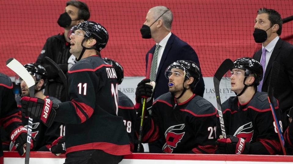 Carolina Hurricanes’ captain Jordan Staal (11) and coach Rod Brind’Amour watch the replay of a Columbus goal by Seth Jones (3) in the first period on Thursday, March 18, 2021 at PNC Arena in Raleigh, N.C.