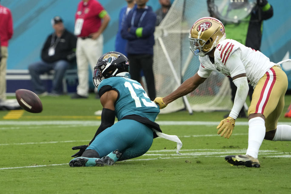 Jacksonville Jaguars wide receiver Christian Kirk (13) catches a pass in front of San Francisco 49ers cornerback Deommodore Lenoir during the second half of an NFL football game, Sunday, Nov. 12, 2023, in Jacksonville, Fla. (AP Photo/John Raoux)