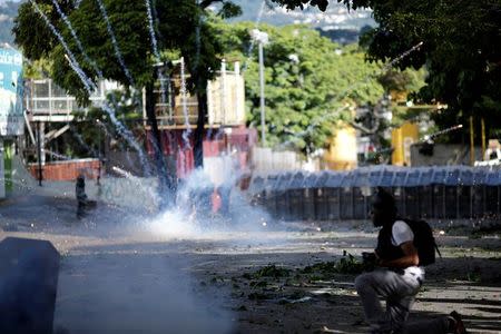 A firework explodes next to riot security force at a rally during a strike in Caracas. REUTERS/Ueslei Marcelino