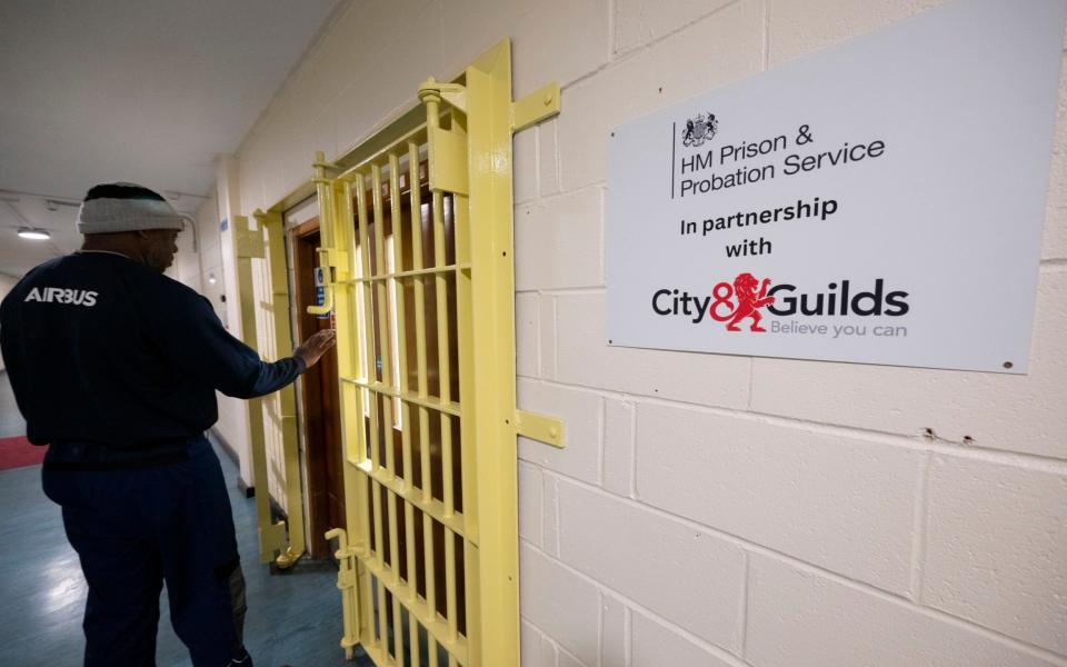 PRISONERS on training for jobs in Industry. A prisoner enters a classroom offering City and Guilds recognized Electrical engineering training. H