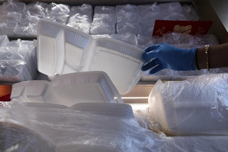 A restaurant worker picks a plastic food boxes at a Kuen Fat Kitchen, a typical lunch stop, in Hong Kong, Wednesday, April 10, 2024. Hong Kong has long been a major producer and consumer of great food, and a great amount of plastic and Styrofoam to go with it. That’s going to change as new legislation aiming to stop the sale and distribution of Styrofoam products and single-use plastic cutlery went into effect on Monday, April 22, 2024.(AP Photo/Louise Delmotte)