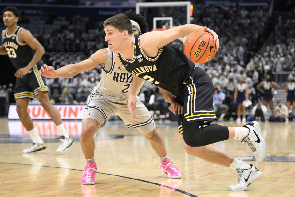 Villanova guard Collin Gillespie, front, drives to the basket against Georgetown guard Dante Harris, back, during the first half of an NCAA college basketball game, Saturday, Jan. 22, 2022, in Washington. (AP Photo/Nick Wass)