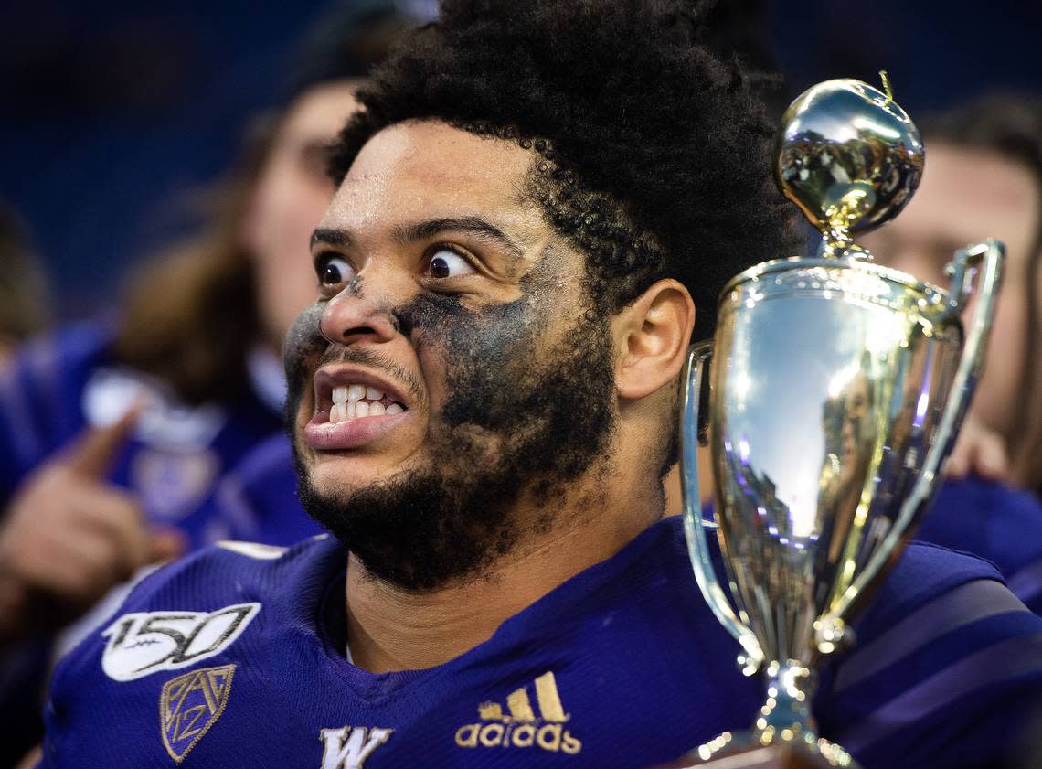 Former Washington Huskies offensive lineman Nick Harris (56) reacts as he holds the Apple Cup trophy after UW beat Washington State in Husky Stadium in Seattle Nov. 29, 2019. The Seahawks agreed to an NFL free-agent contract with Harris on March 13, 2024.