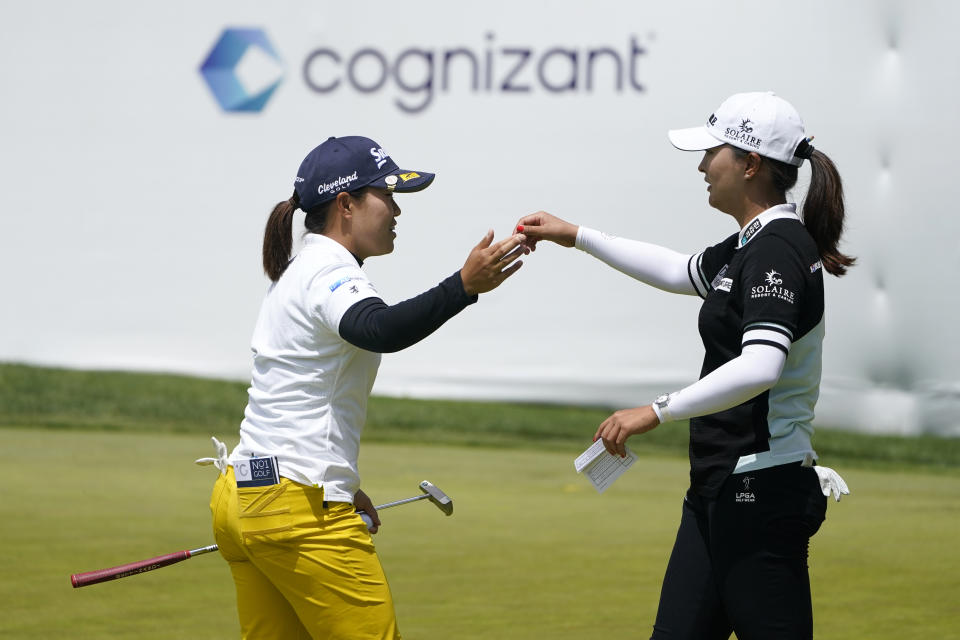 Nasa Hataoka, of Japan, greets Jin Young Ko, of South Korea, right, on the 18th green after finishing their first round of the LPGA Cognizant Founders Cup golf tournament, Thursday, May 12, 2022, in Clifton, N.J. (AP Photo/Seth Wenig)