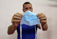 Swedish boxing coach Daniel Nash displays a medical face mask that was provided by a hotel staff ahead of AIBA Women's World Boxing Championships in New Delhi, India, November 12, 2018. REUTERS/Anushree Fadnavis