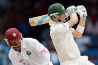 Batsman Michael Clarke (R) of Australia plays a shot that was caught out by Shane Shillingford of West Indies during the first day of the second-of-three Test matches between Australia and West Indies April 15, 2012 at Queen's Park Oval in Port of Spain. West Indies wicketkeeper Carlton Baugh (L) backs up play. AFP PHOTO/Stan HONDA