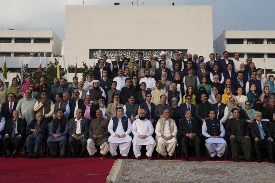 Pakistan's Prime Minister Shehbaz Sharif, fourth right, poses for a group photo with lawmakers of the National Assembly at the end of the last session of the current parliament, in Islamabad, Pakistan, Wednesday, Aug. 9, 2023. Pakistan's prime minister took a formal step Wednesday toward dissolving parliament, starting a possible countdown to a general election, as his chief political rival fought to overturn a corruption conviction that landed him in a high-security prison over the weekend. (AP Photo/Anjum Naveed)