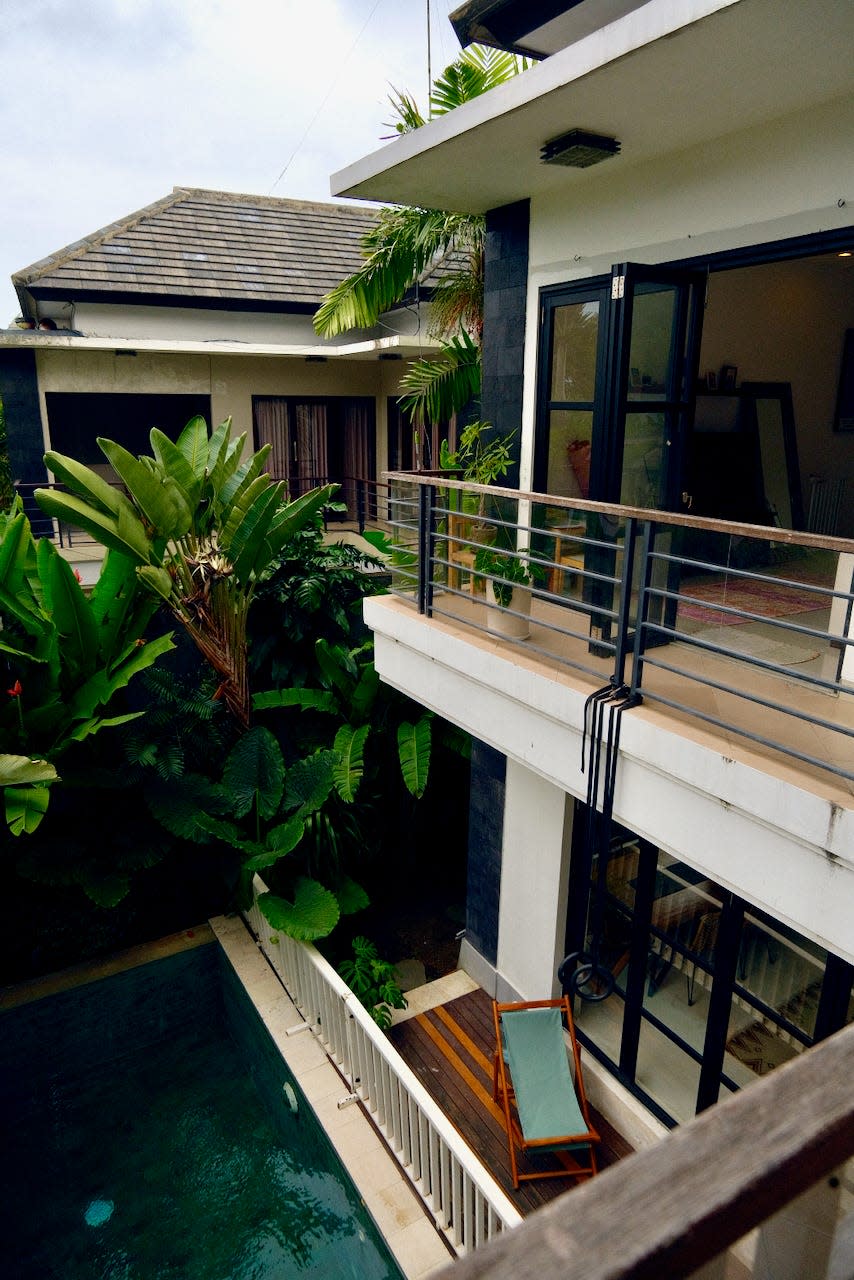 A view of the pool and the exterior of a villa as viewed from the second floor.