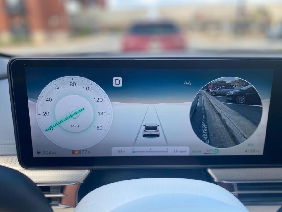 The digital gauge display of a 2024 Genesis GV60 EV shows the car's blind spot view monitor.