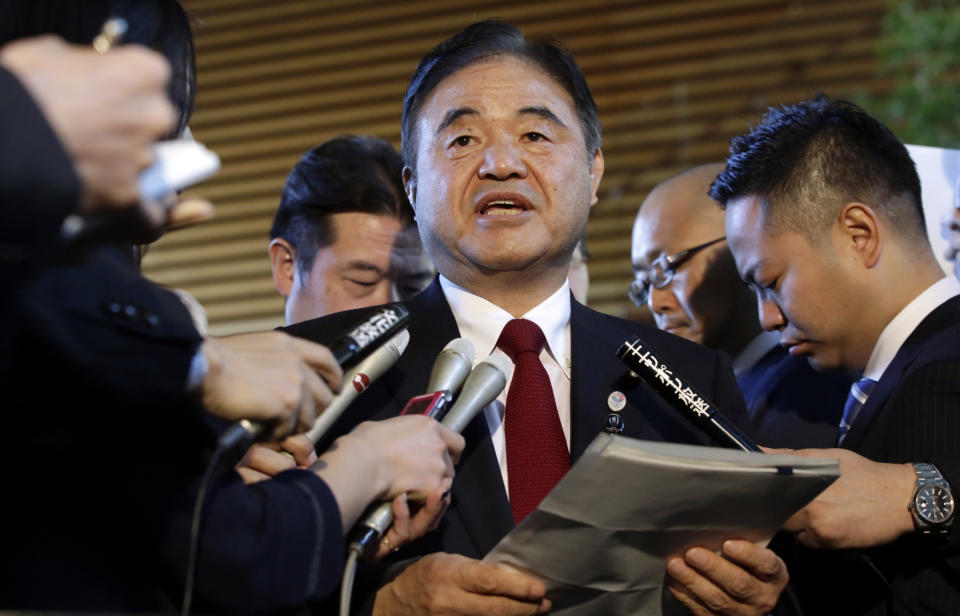 FILE - In this Dec 22, 2015, file photo, Toshiaki Endo, center, minister in charge of the 2020 Tokyo Olympics, speaks with media after a meeting of Cabinet ministers including Japan's Prime Minister Shinzo Abe, at Abe's official residence in Tokyo. Former Olympic minister Endo said at a meeting of the ruling Liberal Democratic Party on Friday, June 5, 2020, that a decision of whether to hold the Games should be made around March, which is a crucial time to finalize participating athletes, NHK said. (AP Photo/Eugene Hoshiko, File)