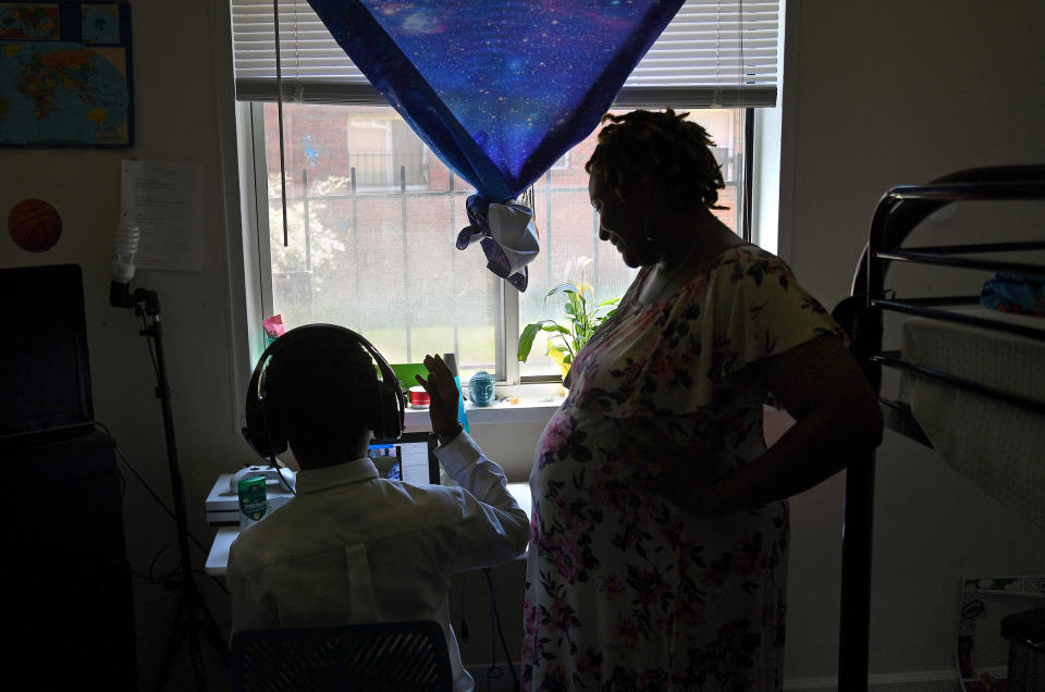 Lakeisha Rollins checks in on her son Amari, age 8, as he does remote summer school work in her apartment in Washington, D.C. on July 14, 2020. Rollins is a single mother who is pregnant with her second child and when the pandemic hit in March, she bunkered down in her apartment with Amari and prepared to wait out the virus.